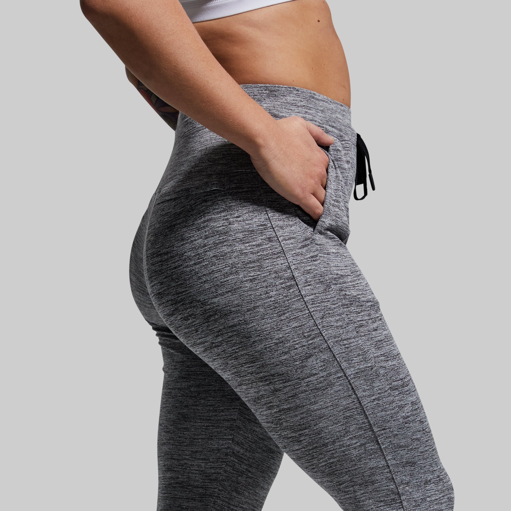 Person wearing gray athletic joggers on a plain background