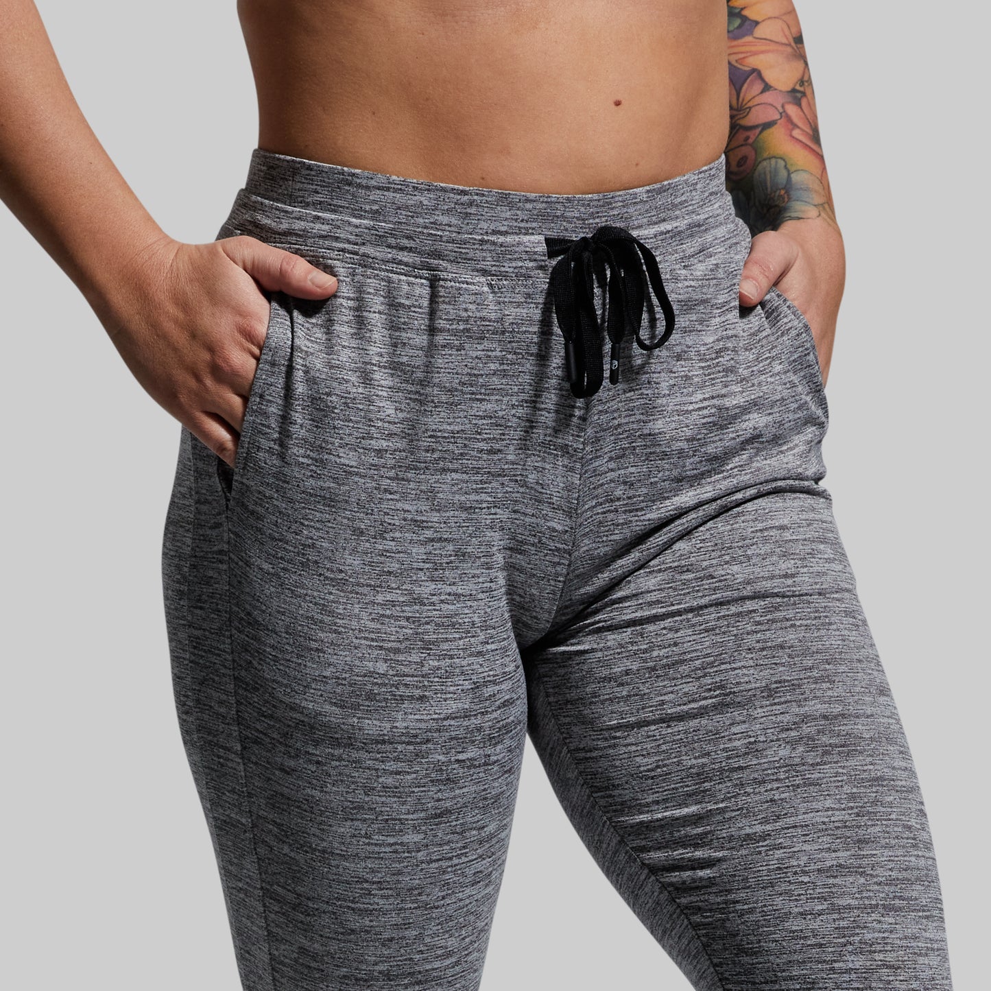 Gray jogger pants worn by a person on a plain background