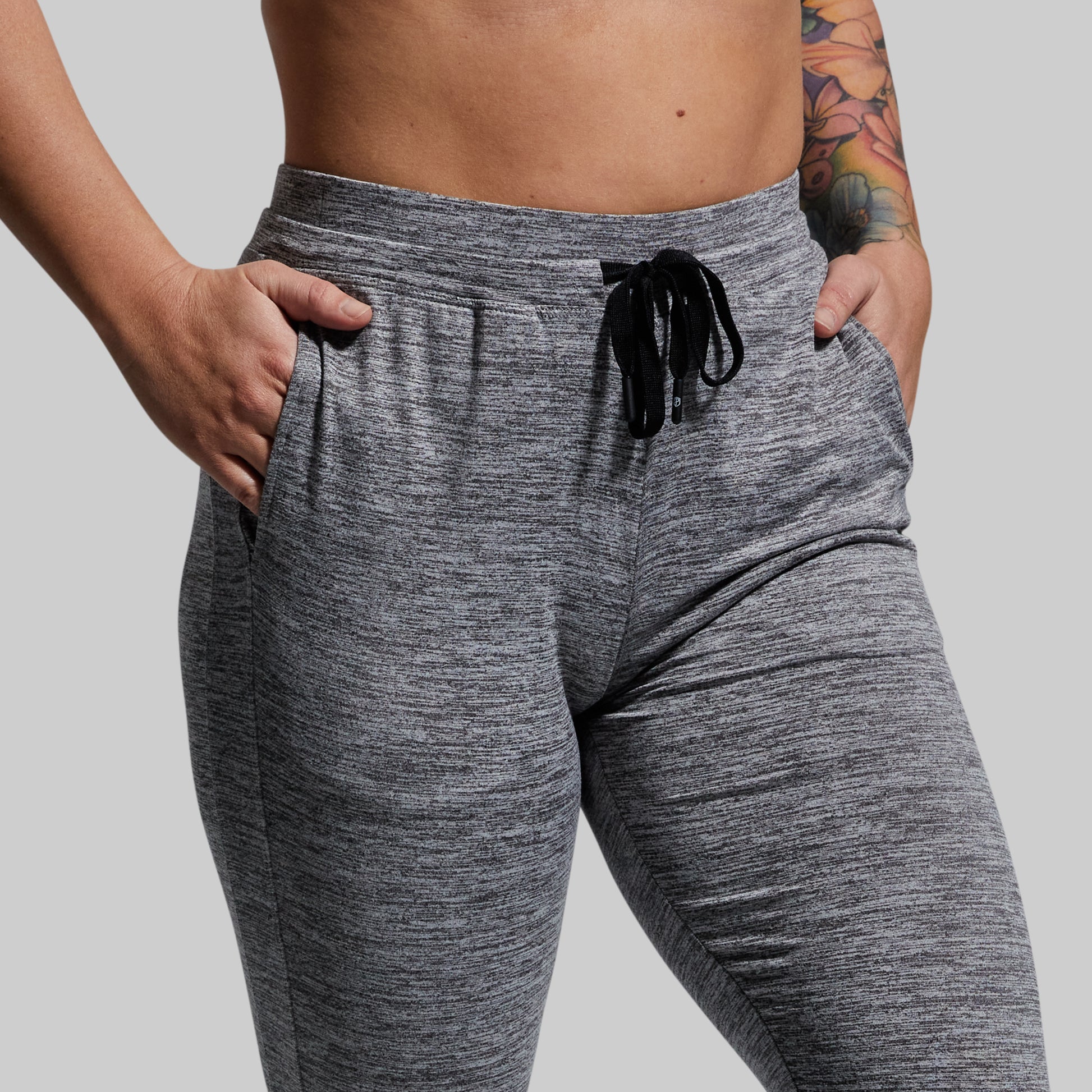 Gray jogger pants worn by a person on a plain background