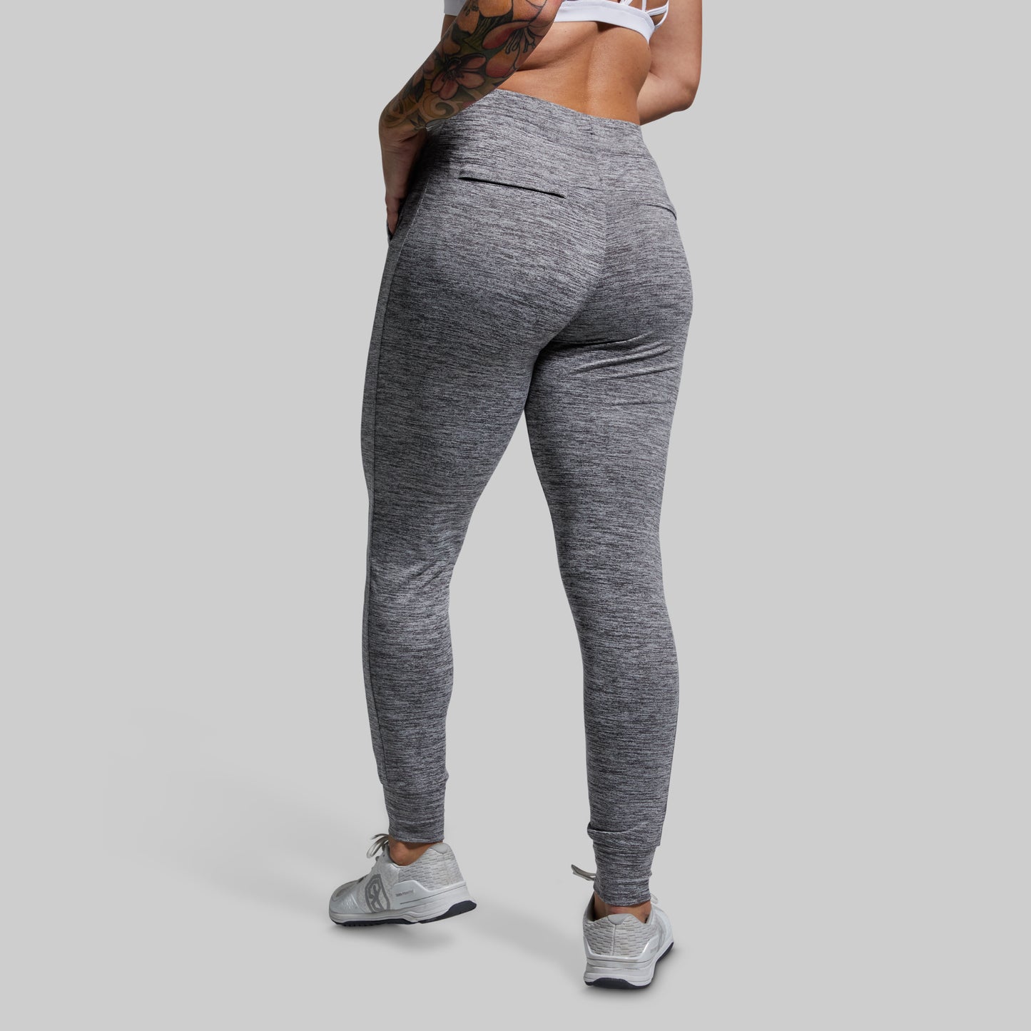Person wearing gray joggers on a plain background