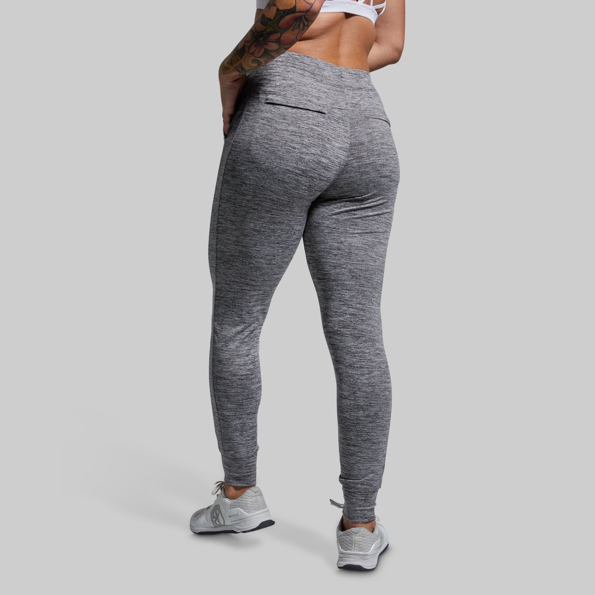 Person wearing gray joggers on a plain background
