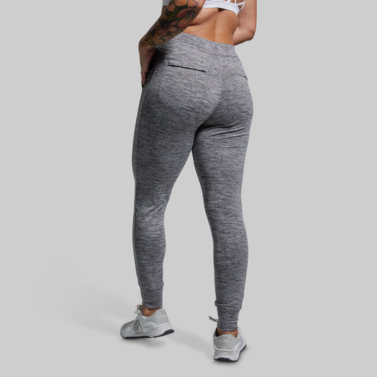 Person wearing gray joggers on a plain background