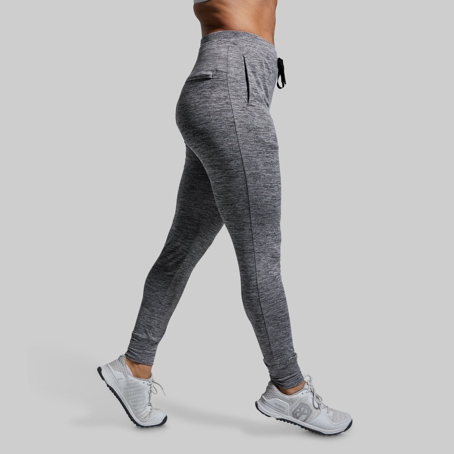 Person wearing gray athletic joggers on a plain background