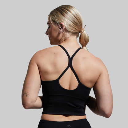 Woman wearing a black sports bra with a gray background