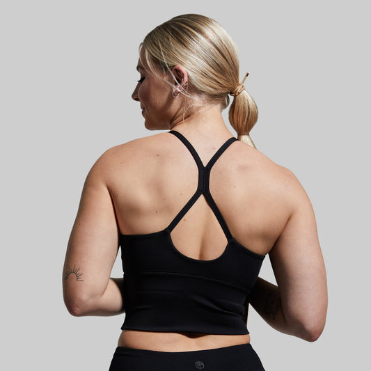 Woman wearing a black sports bra with a gray background