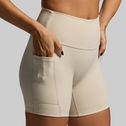 Beige ribbed shorts worn by a person on a plain background