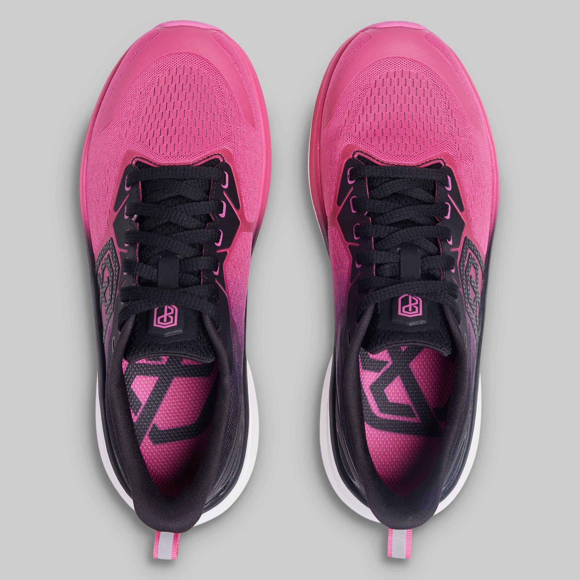 Pink and black running shoes on a gray background