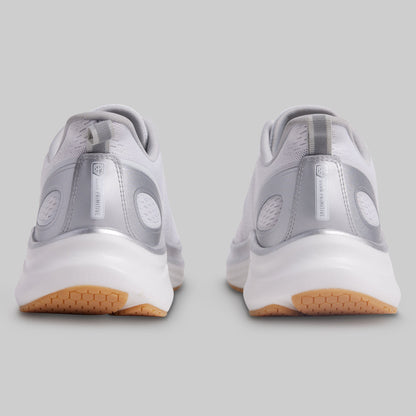 Gray athletic shoes with white soles and brown soles on a gray background