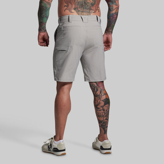 Person wearing gray shorts on a plain background