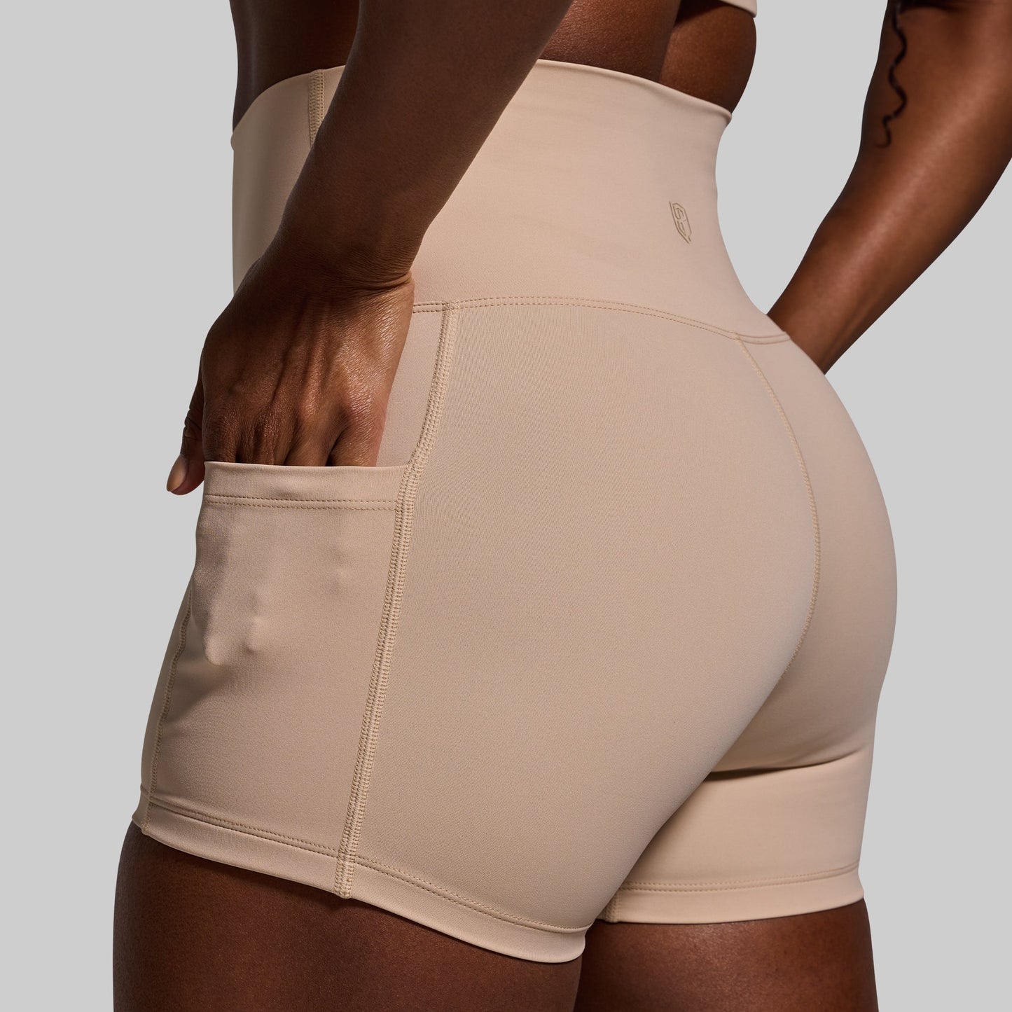 Beige athletic shorts worn by a person on a plain background