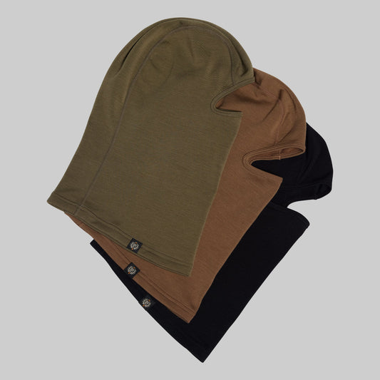 Stack of three balaclavas in green, brown, and black on a light gray background