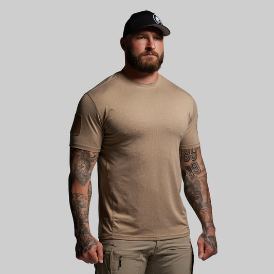 Man wearing a brown t-shirt and cap on a gray background