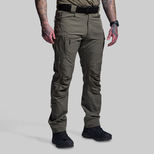 Person wearing green tactical pants on a gray background