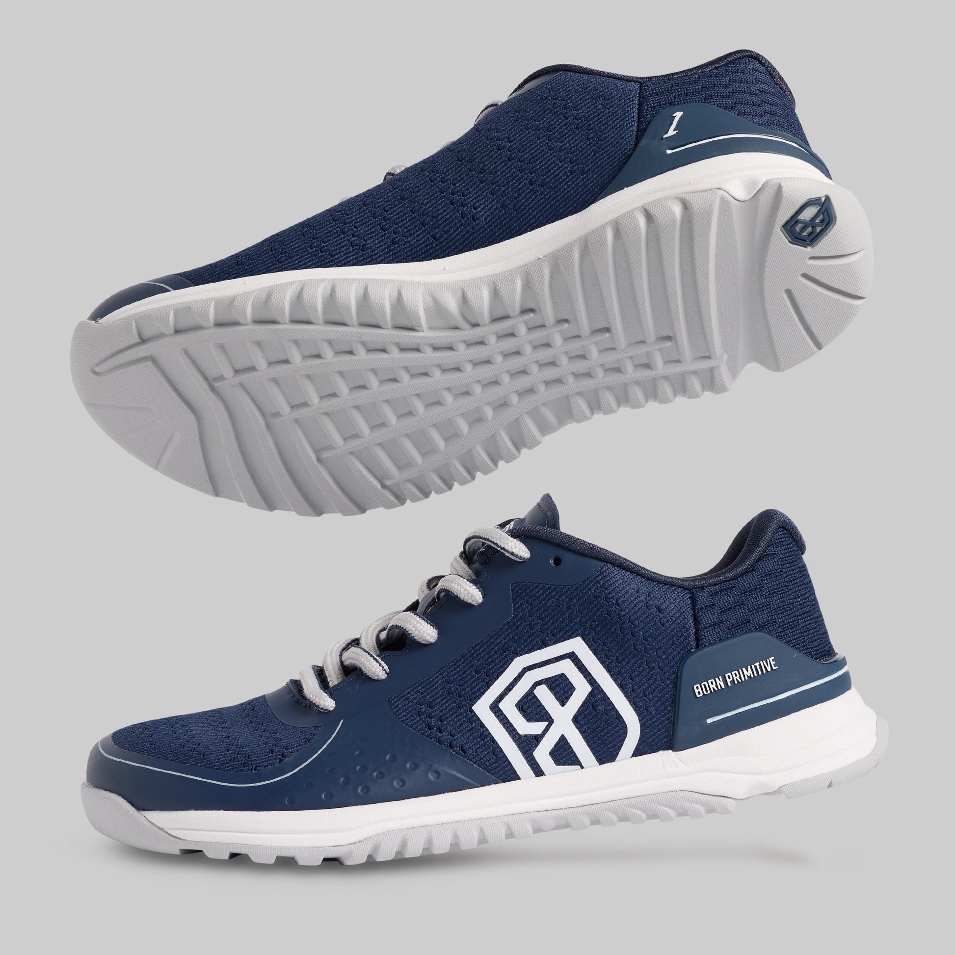 Navy training shoes with white soles on a gray background