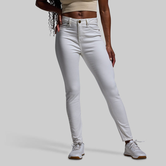 Person wearing white jeans on a plain background