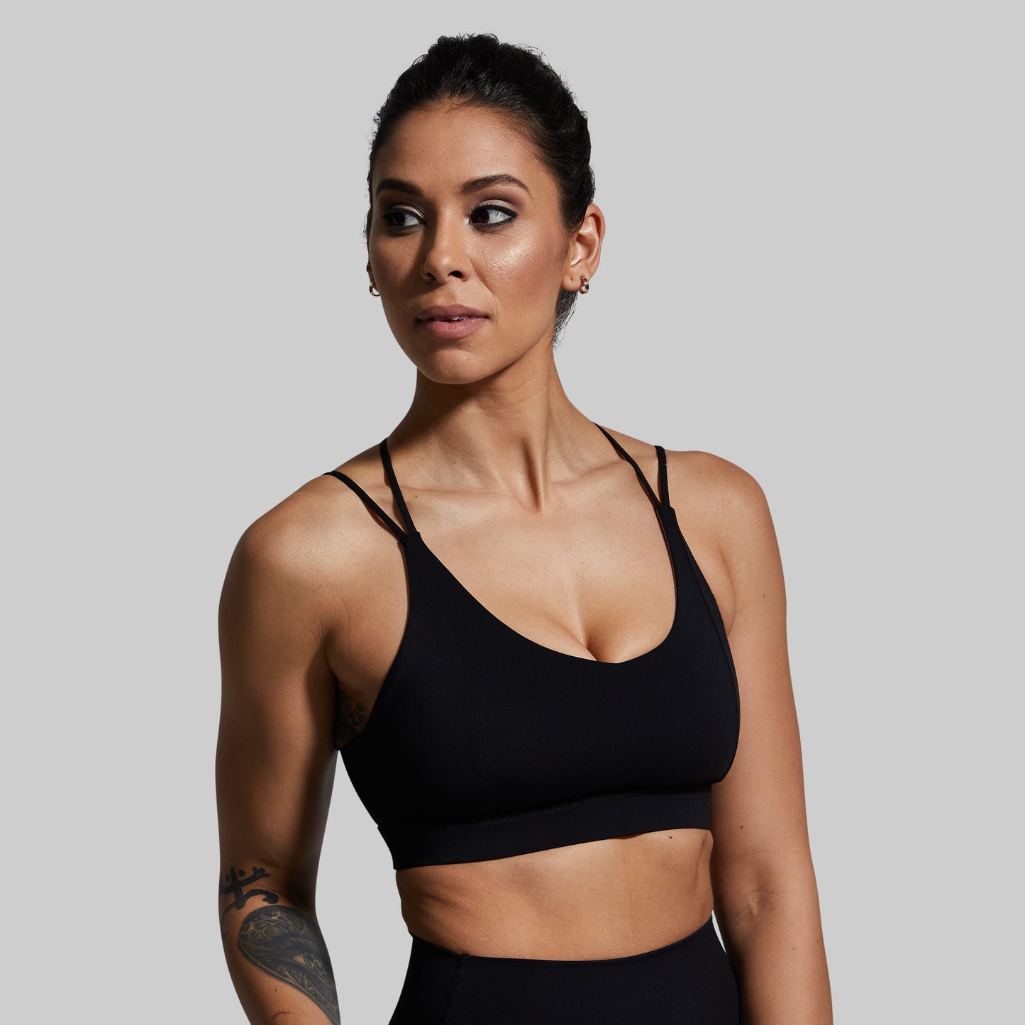 Woman wearing a black sports bra against a plain background