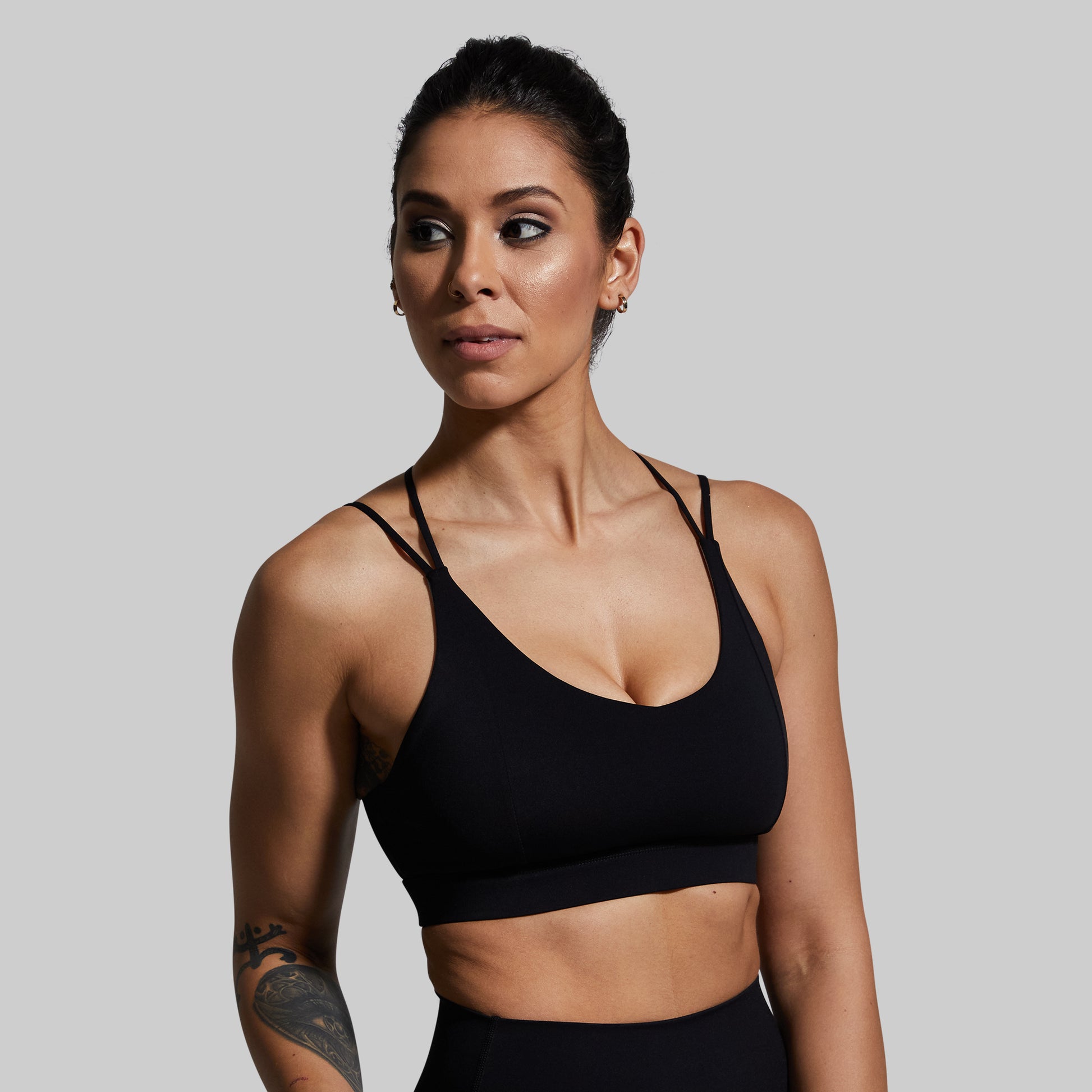 Woman wearing a black sports bra against a plain background