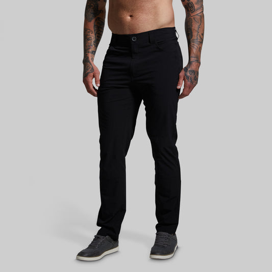 Person wearing black pants on a gray background