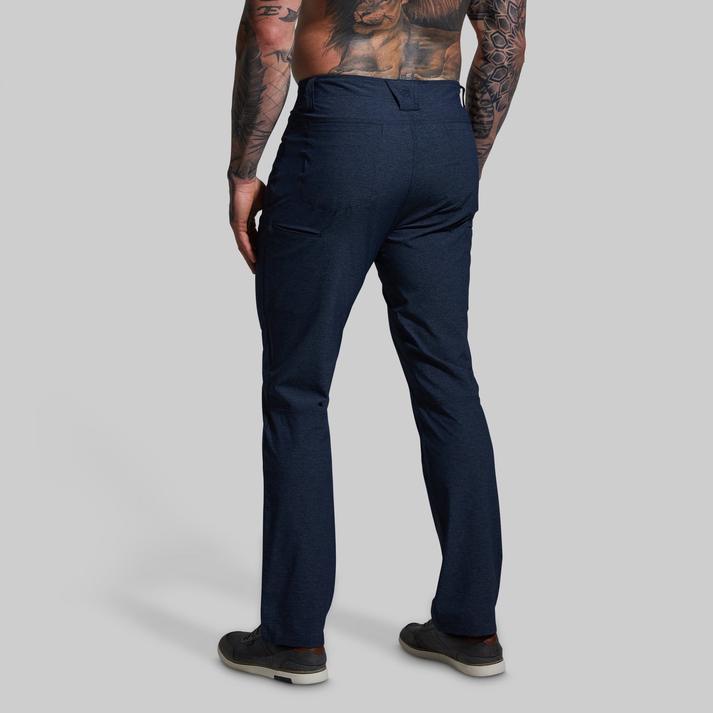 Person wearing navy pants on a plain background