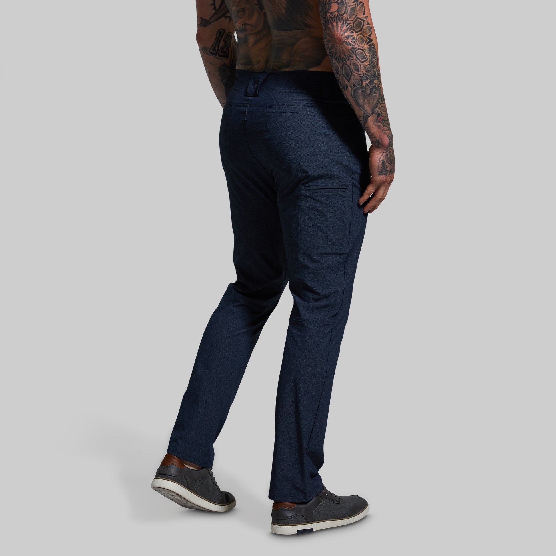 Person wearing navy blue pants on a gray background