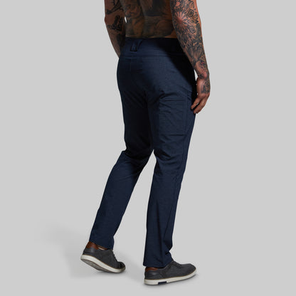 Person wearing navy blue pants on a gray background