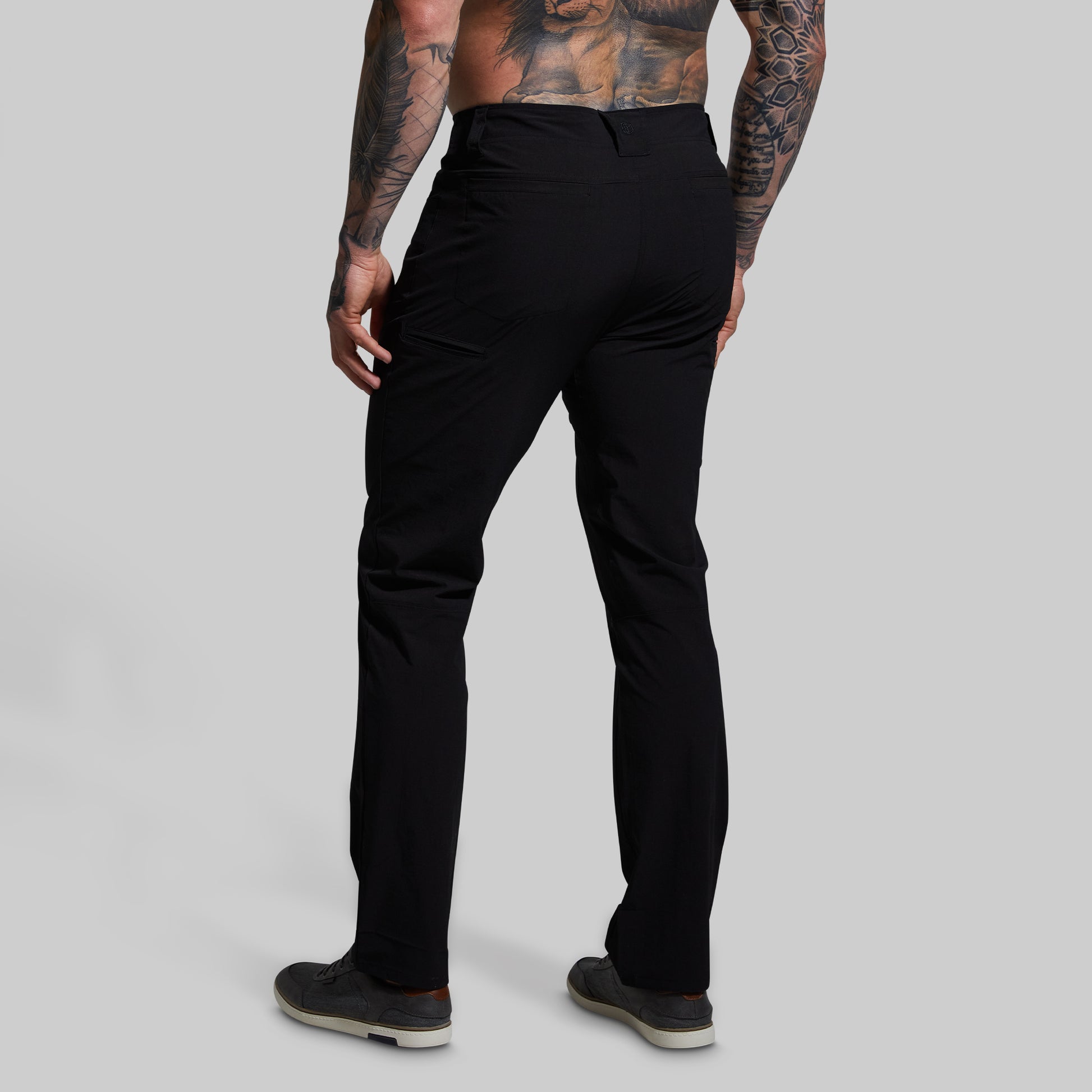 Person wearing black pants on a gray background