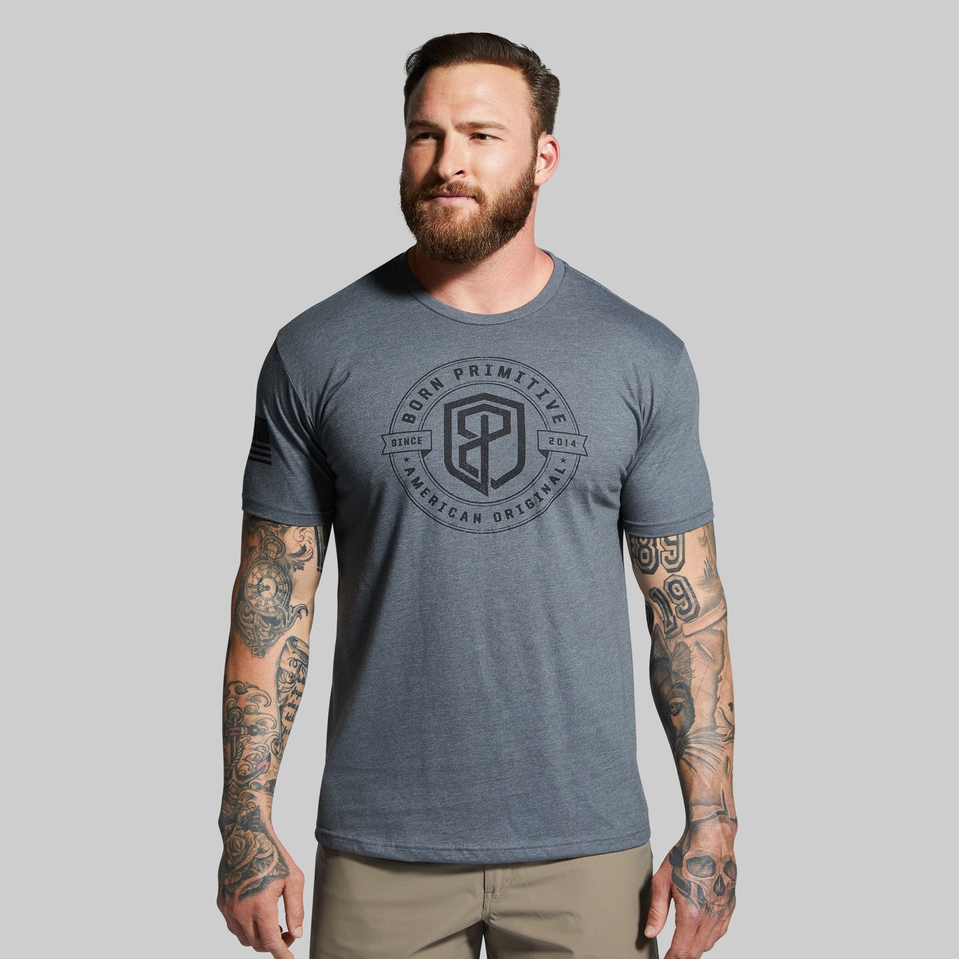 Man wearing a gray t-shirt with a logo on a gray background