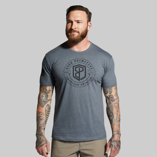 Man wearing a gray t-shirt with a logo on a gray background