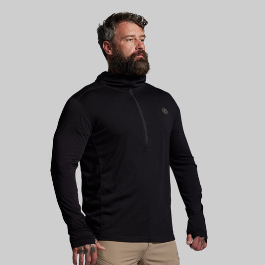 Man wearing a black long-sleeve shirt with a logo on a gray background