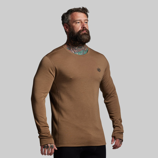 Man wearing a brown long-sleeve shirt against a gray background