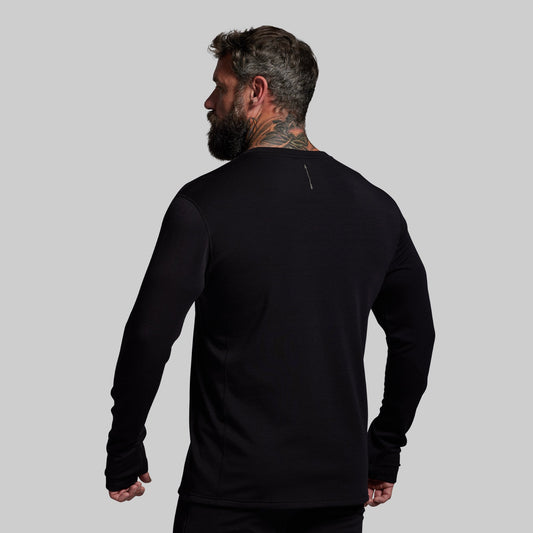 Man wearing a black long-sleeve shirt on a gray background