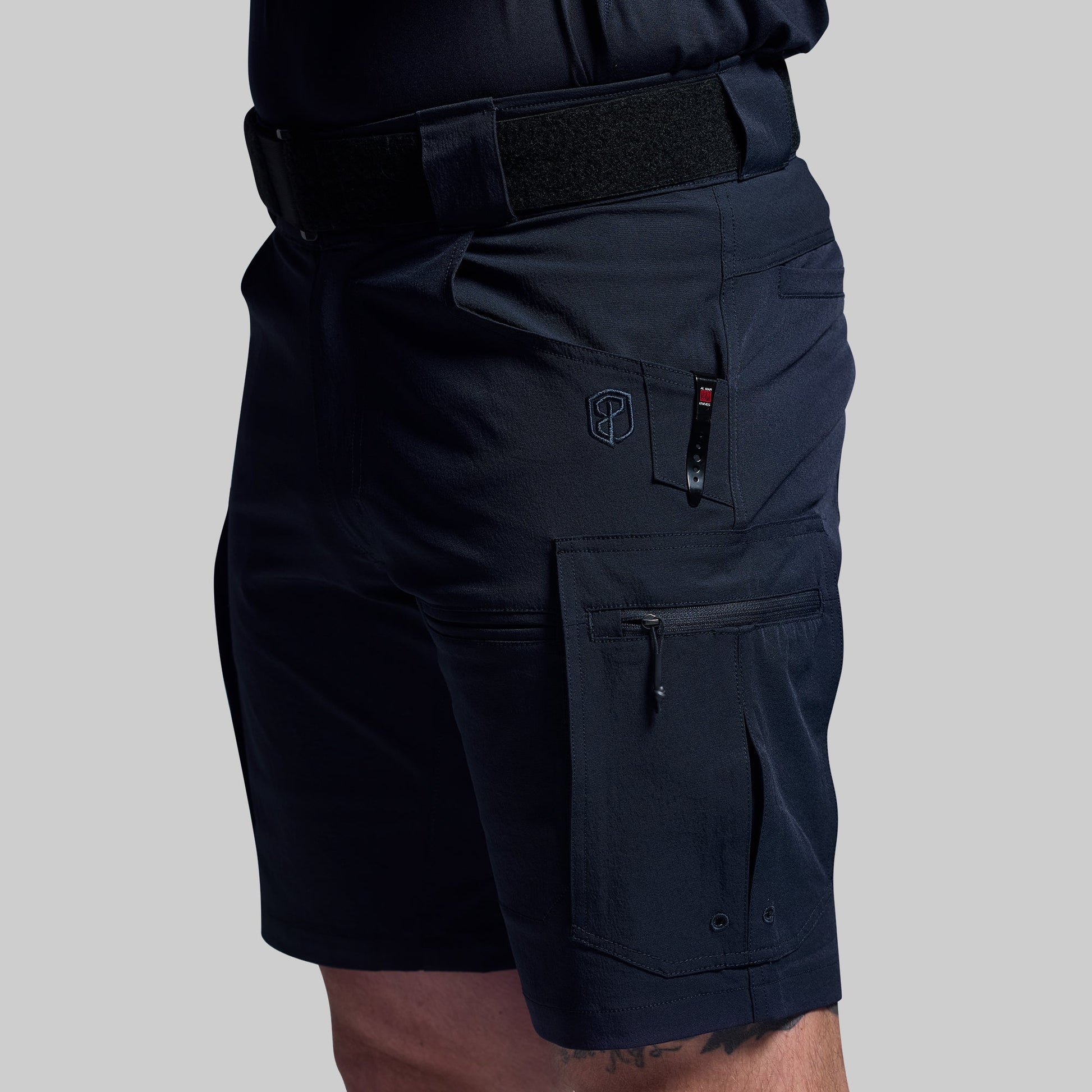 Blue tactical shorts with multiple pockets on a gray background