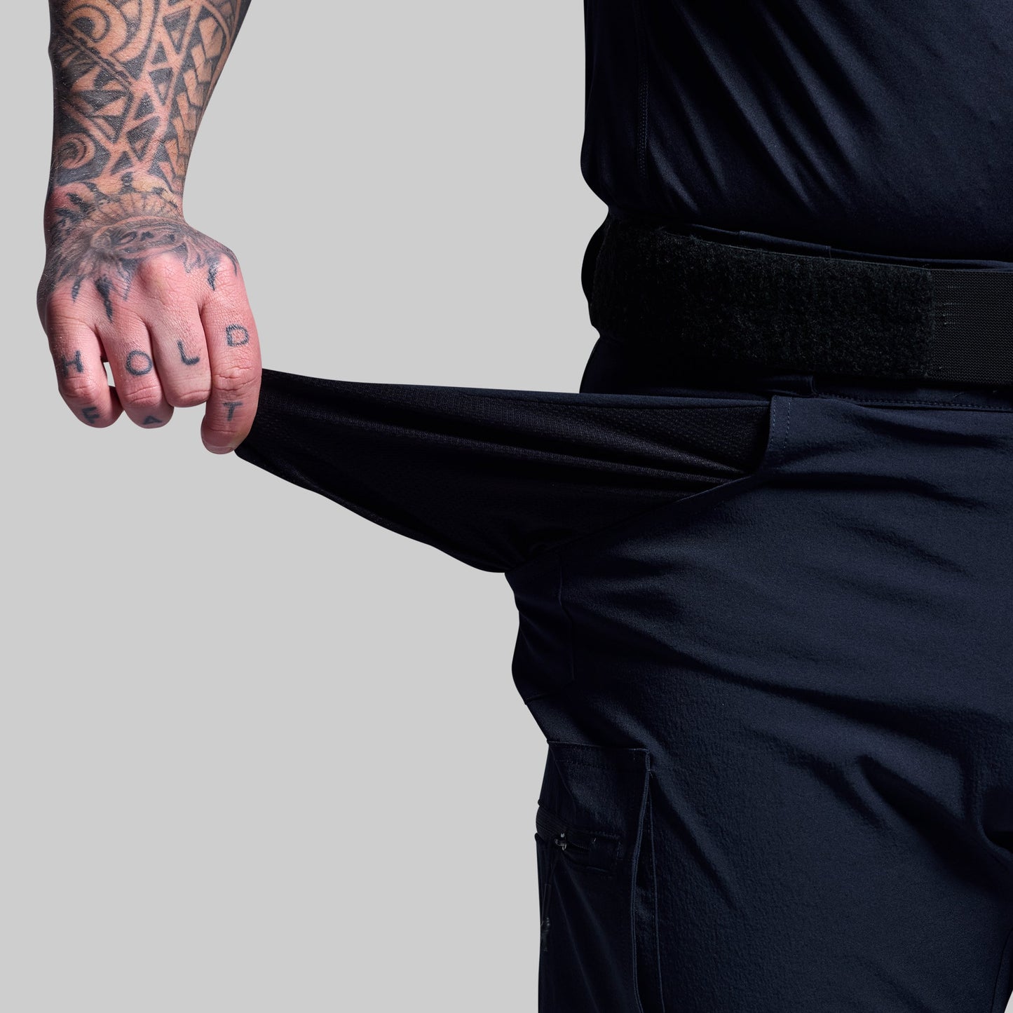 Person wearing dark blue shorts showing the pocket fabric.