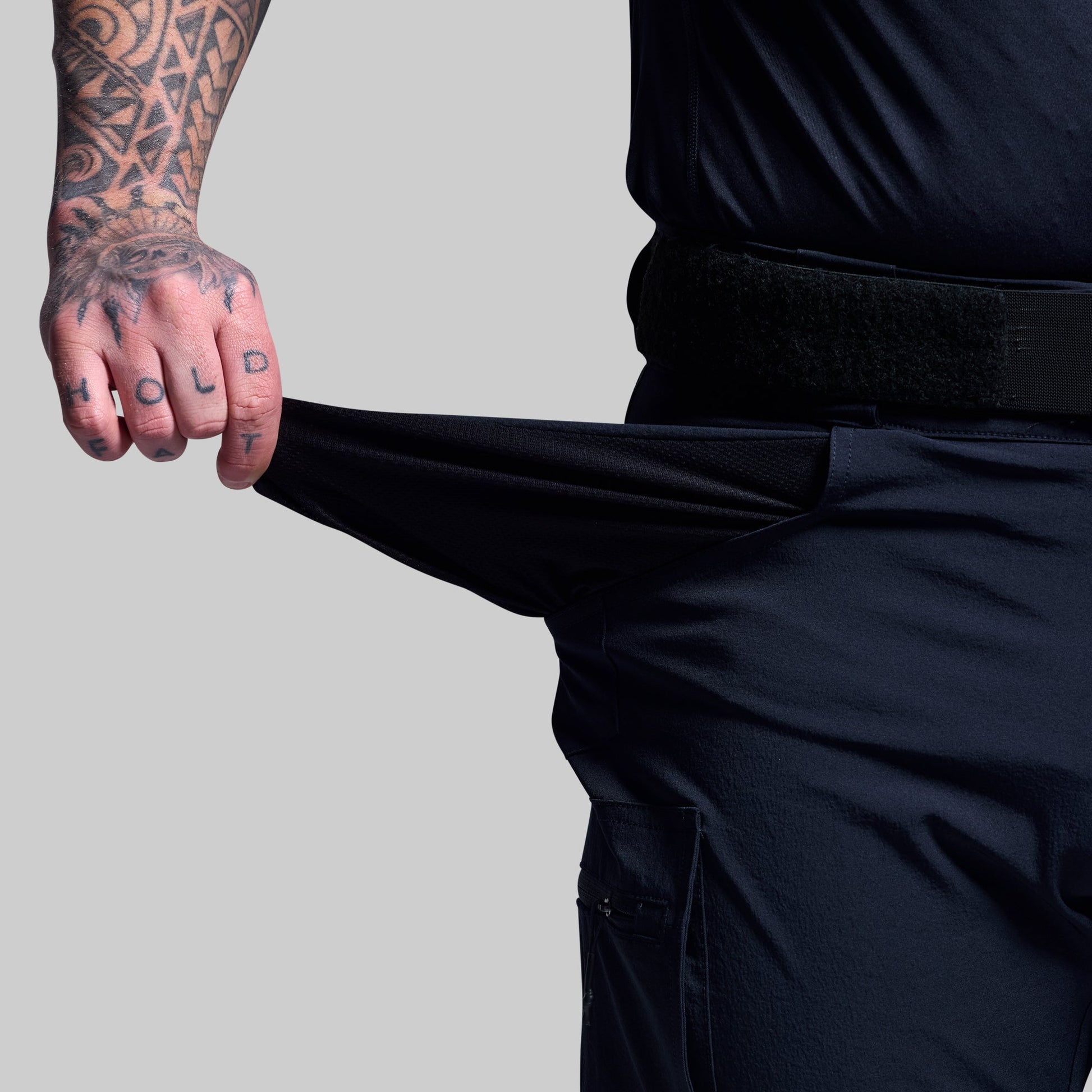 Person wearing dark blue shorts showing the pocket fabric.