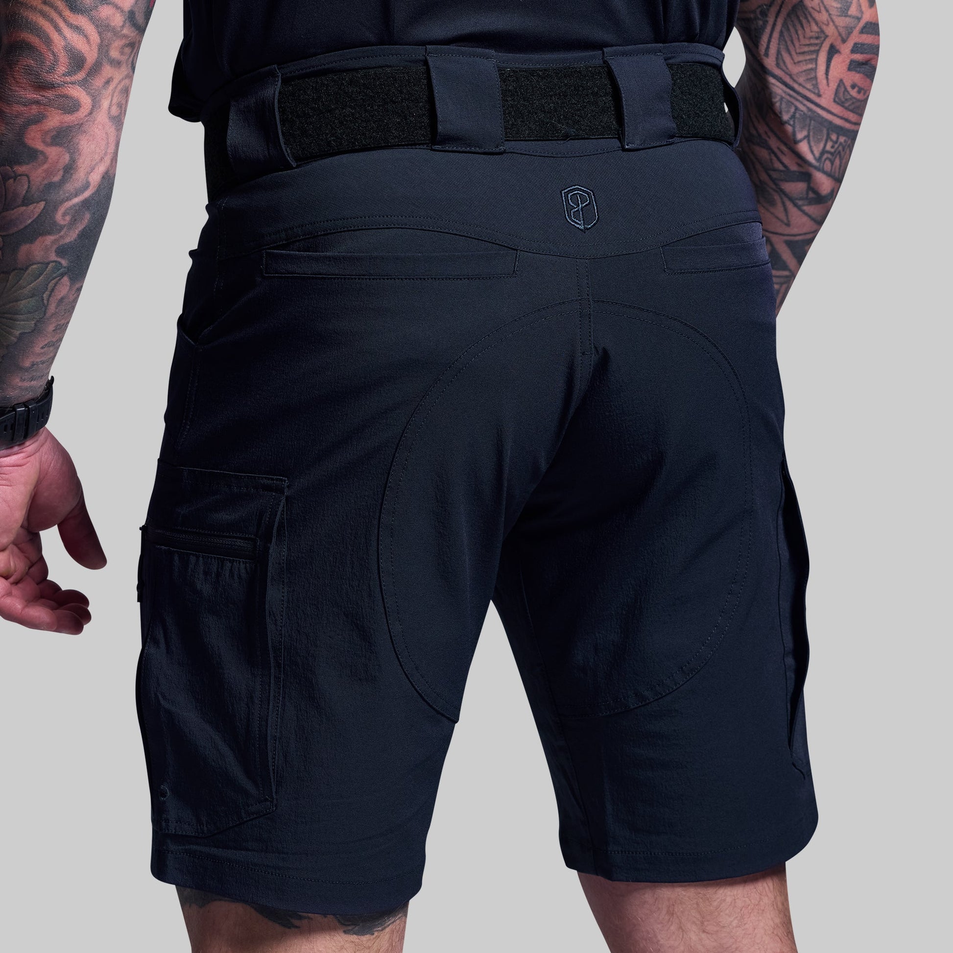 Blue tactical shorts worn by a person on a gray background