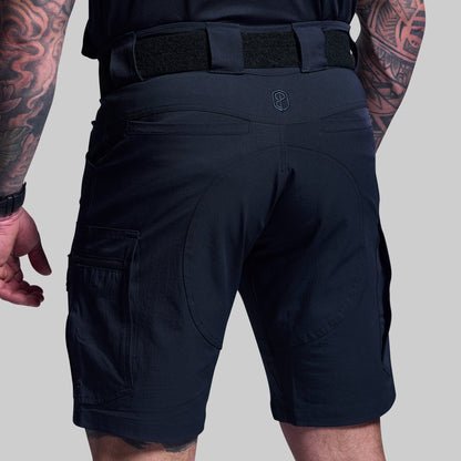 Blue tactical shorts worn by a person on a gray background