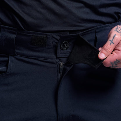 Person wearing blue tactical shorts with a close-up of the waistband.