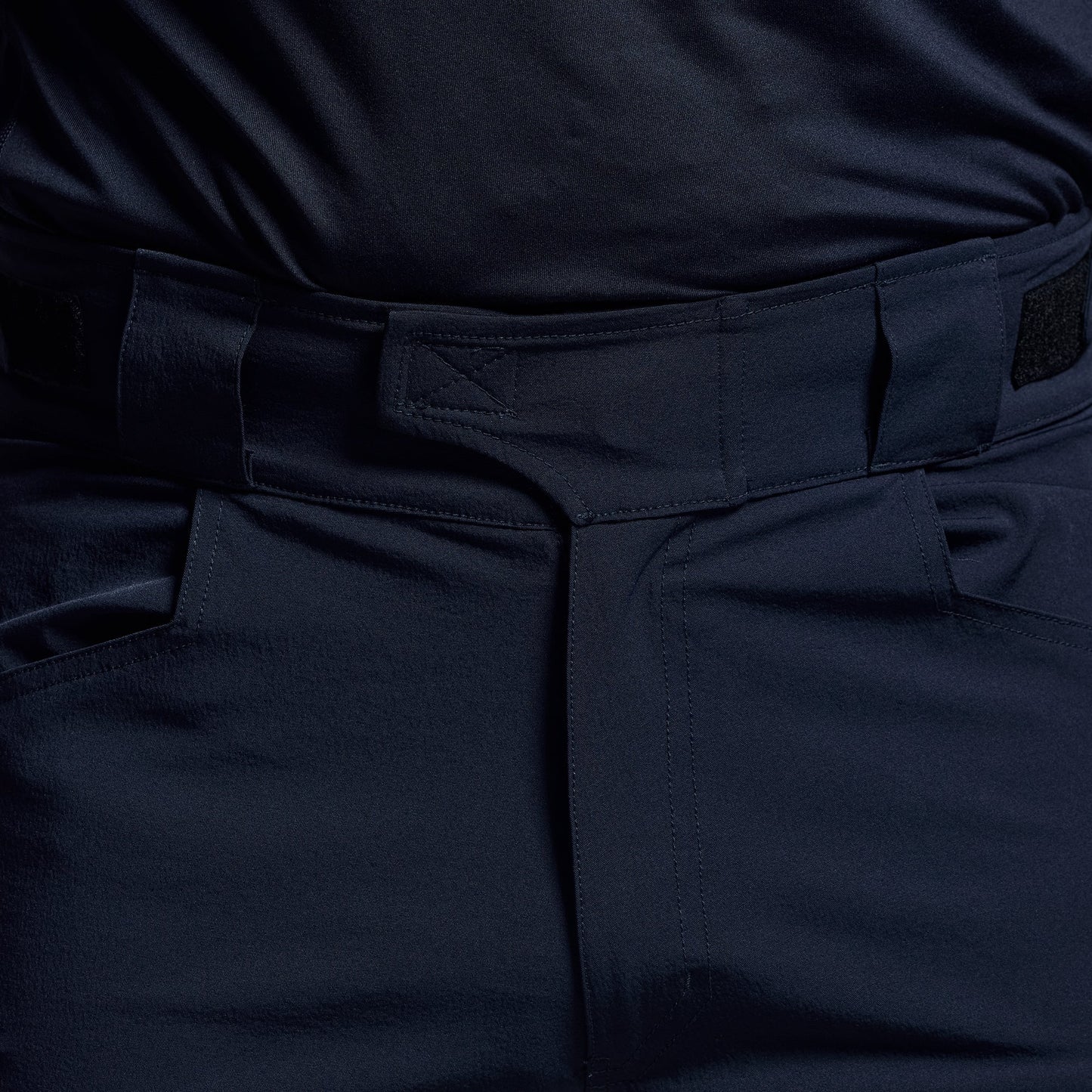Close-up of the waistband on dark blue tactical shorts.