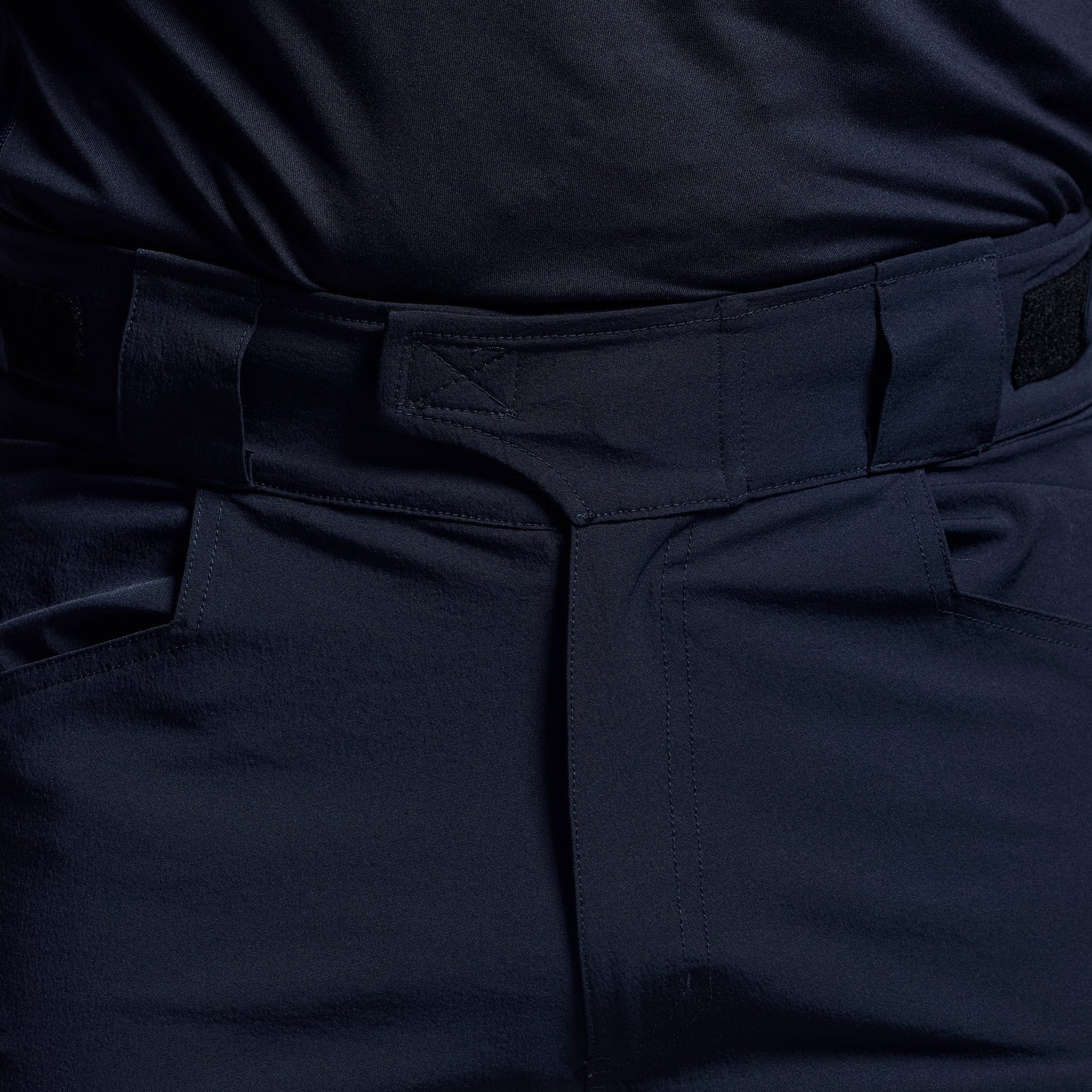 Close-up of the waistband on dark blue tactical shorts.