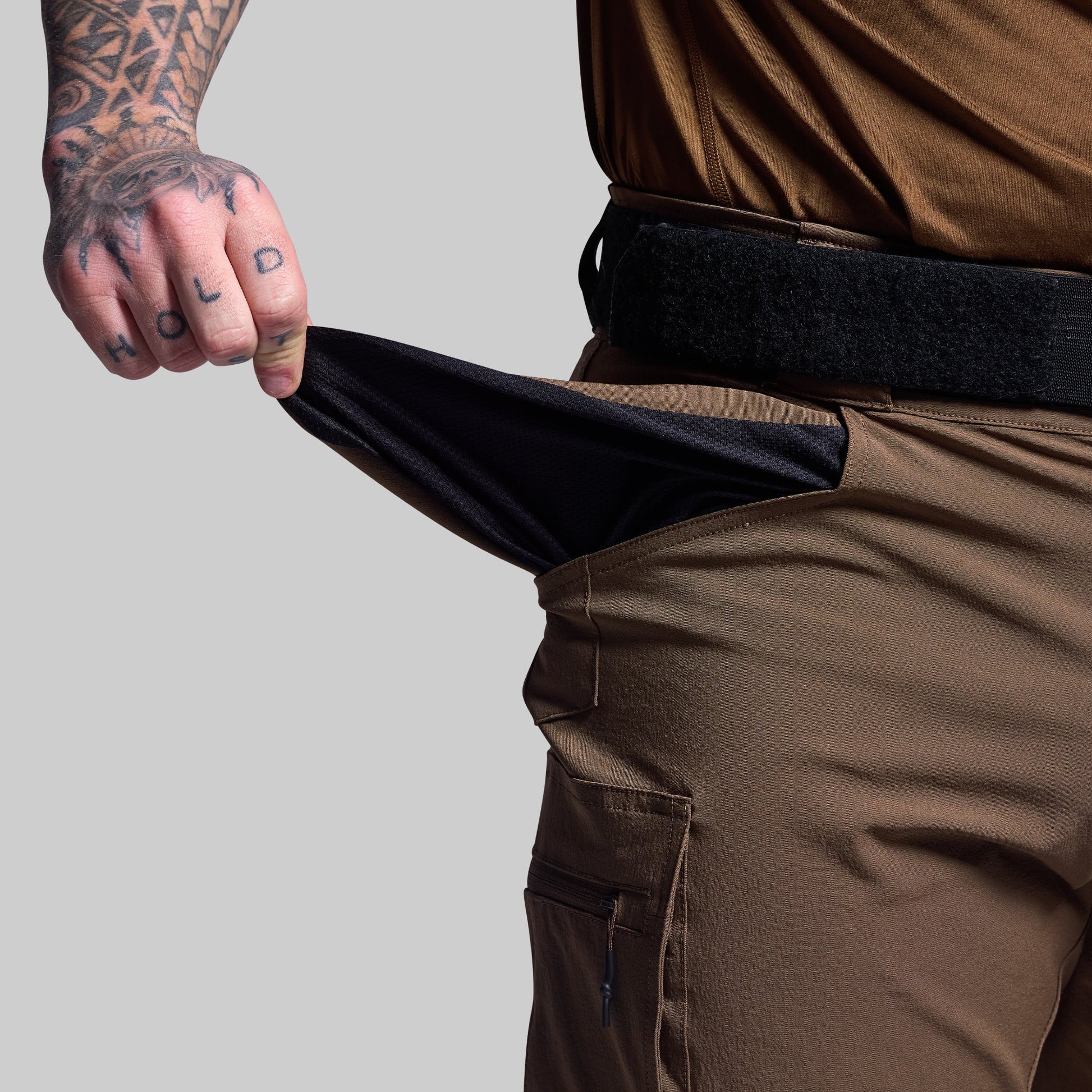Person wearing brown shorts showing the pocket fabric.