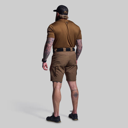Man wearing a brown shirt and shorts set on a gray background