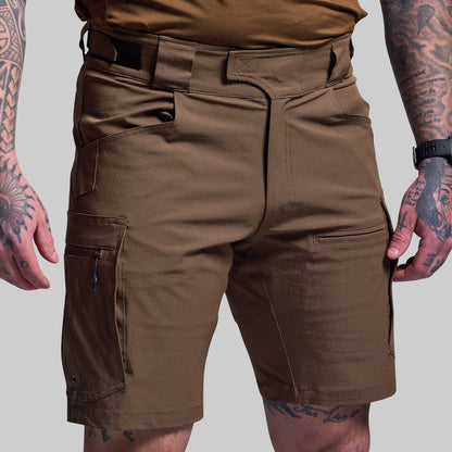 Brown tactical shorts worn by a person with tattoos on a gray background