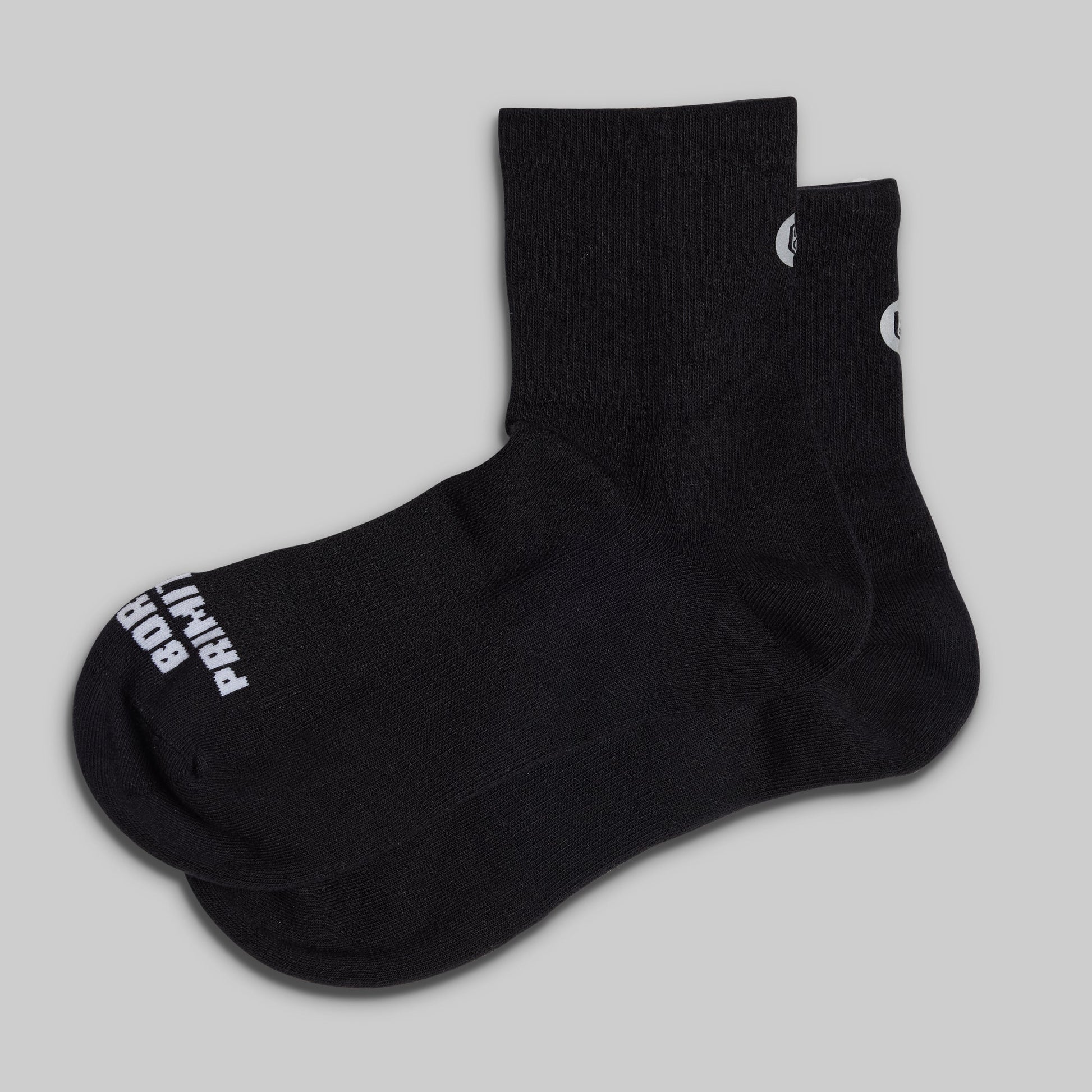 Black socks with white branding on a light gray background