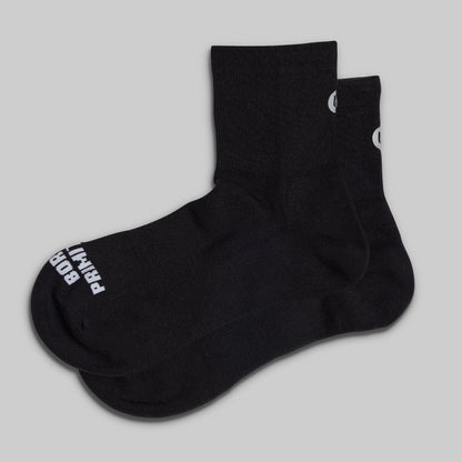 Black socks with white branding on a light gray background
