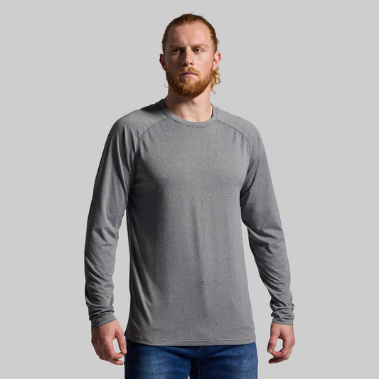 Man wearing a gray long-sleeve shirt against a plain background