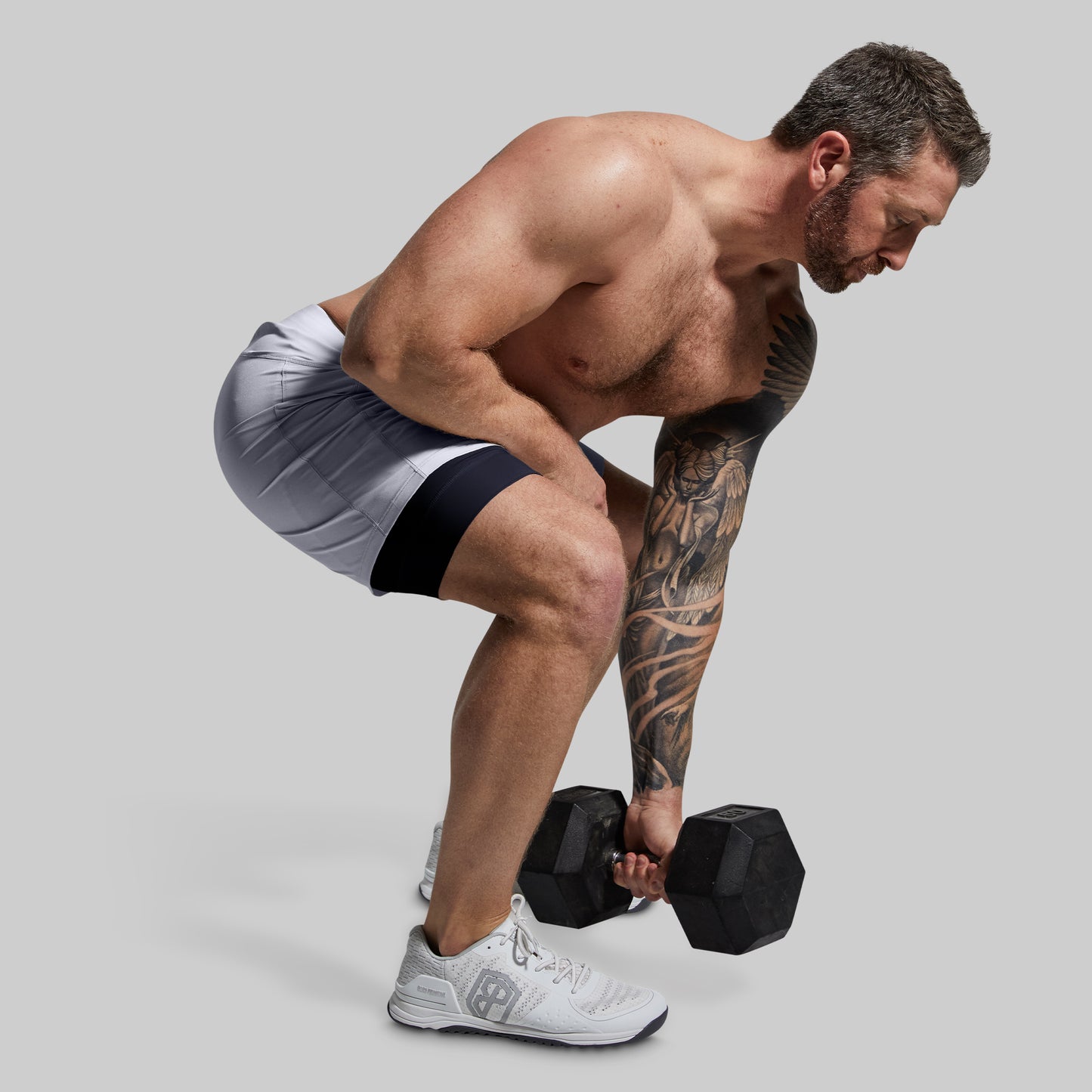 Man exercising with dumbbells on a plain background
