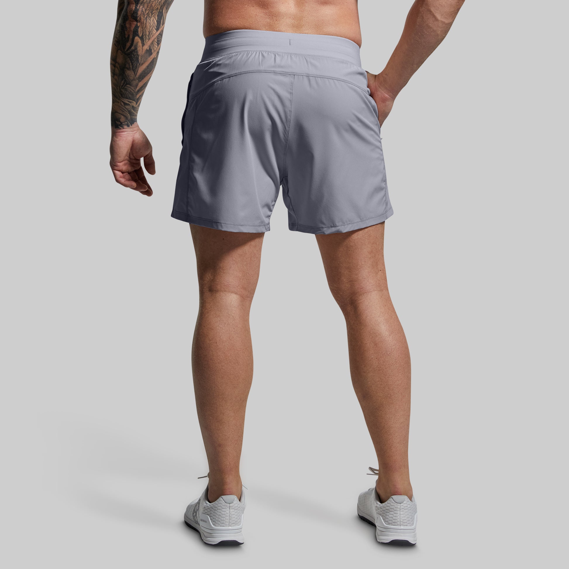 Person wearing gray athletic shorts on a plain background