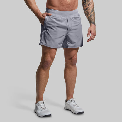 Person wearing gray athletic shorts on a plain background
