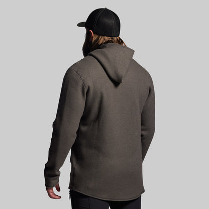 Person wearing a gray hoodie and black cap from behind on a light gray background