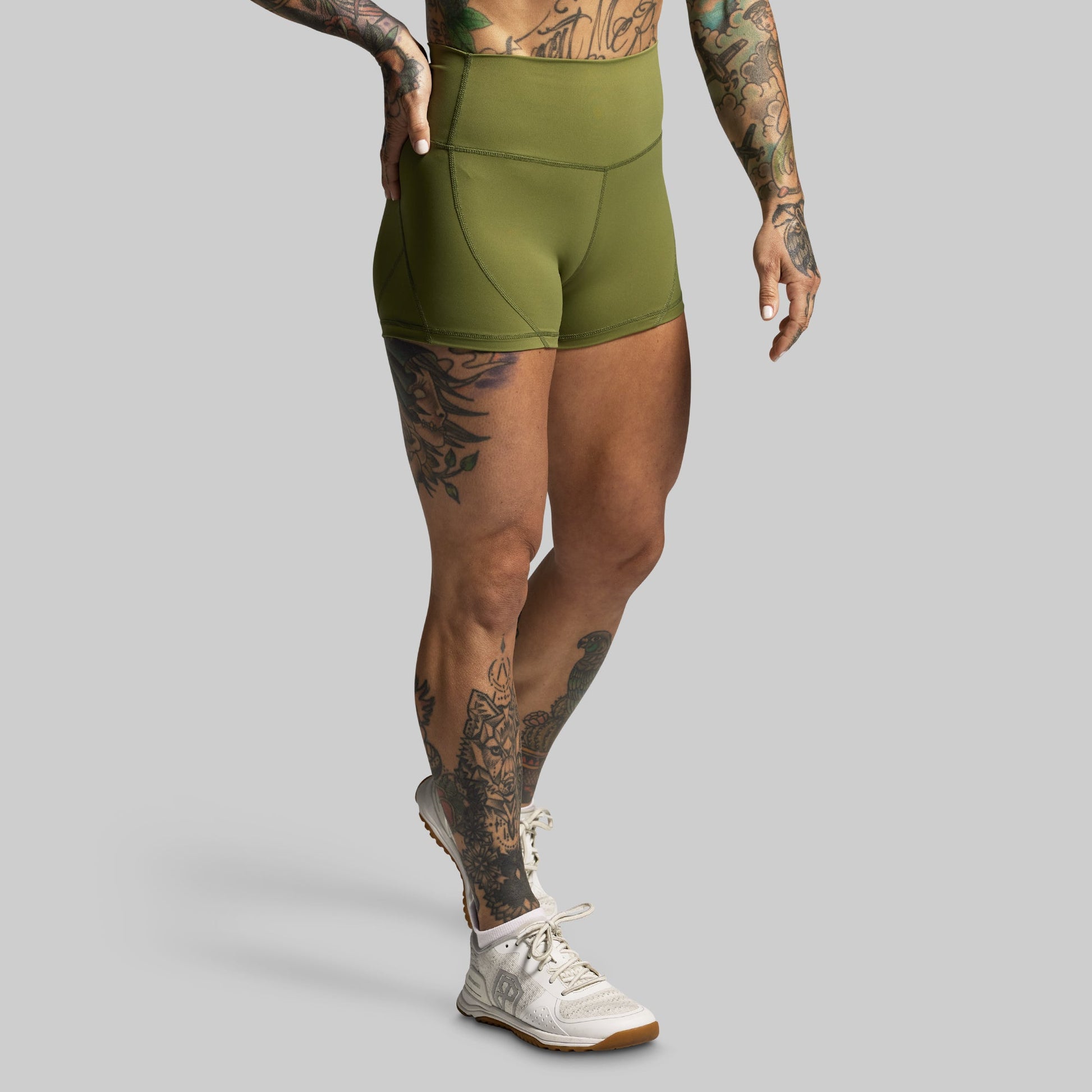 Person wearing green athletic shorts on a gray background